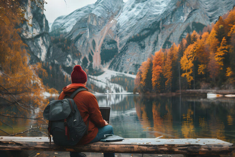 A man sitting on a rock in the mountains enjoying the scenic vie